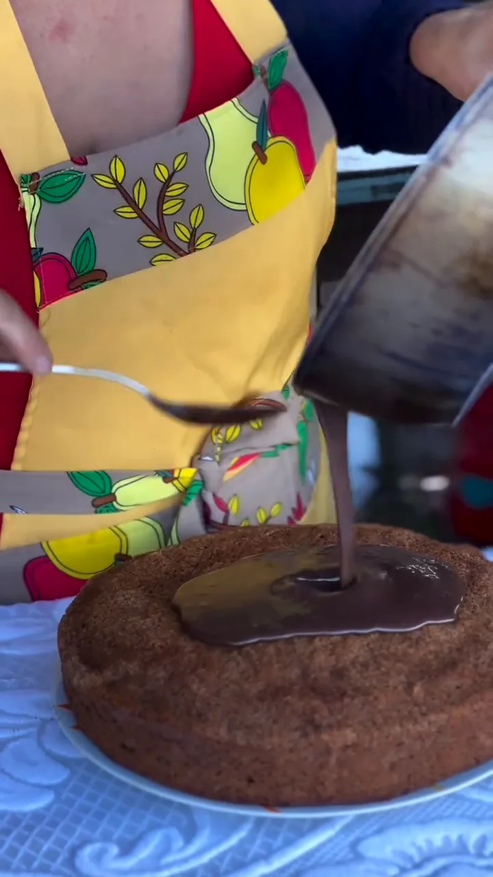 Bolo recebendo cobertura de chocolate